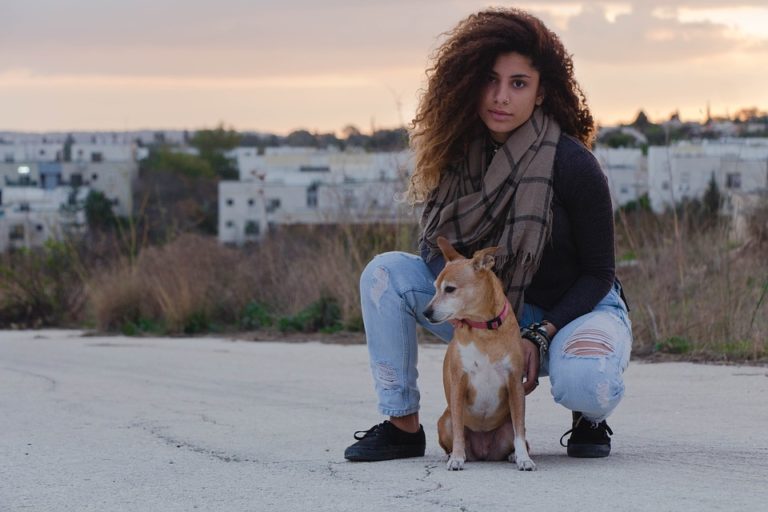 Persoon hurkend bij kleine hond