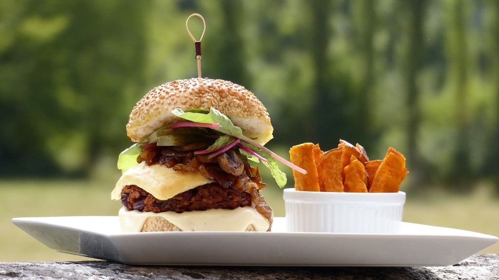 een rijkelijk gevulde burger en patat