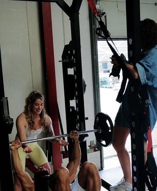 Leonore aan het coachen bij een fitnessapparaat