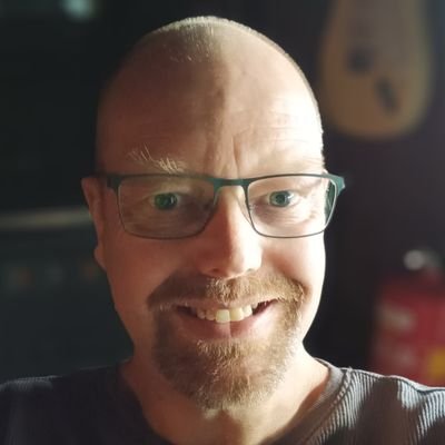 Mindert Dusselaar Een afbeelding van fotograaf Mindert Dusselaar, een glimlachende man met een baardje en een bril.