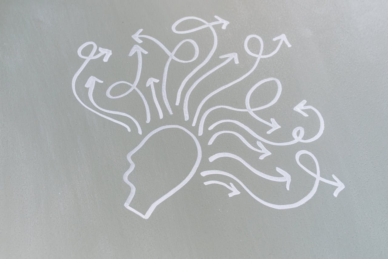 krijttekening van gestileerd hoofd waar pijltjes vandaan kronkelen