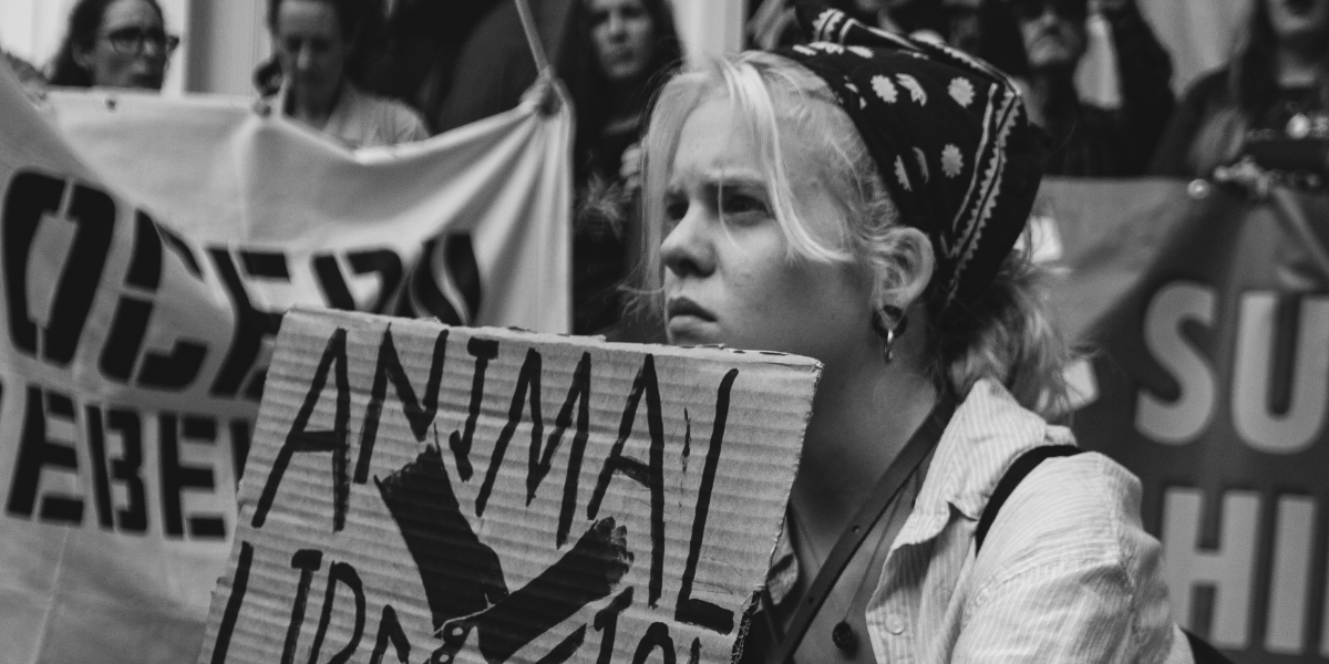 Een vrouw houdt tijdens een protest een bord op waarop te lezen valt: 'animal liberation'.