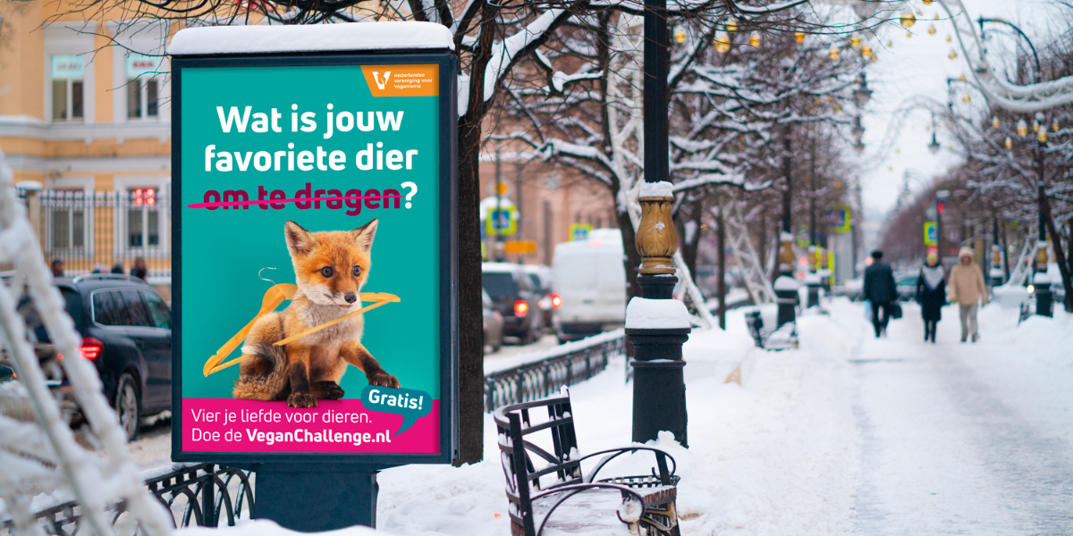Impressie van het campagnebeeld van de NVV met een vosje erop op een billboard in een besneeuwde straat.