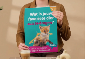 Vrouw met poster van campagne Wat is jouw favoriete dier? met vosje erop