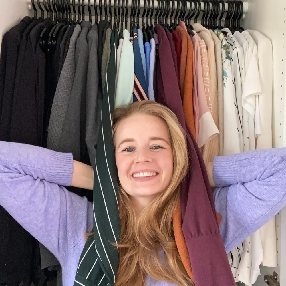 saskia-van-amerongen-in-kledingkast Foto van Saskia van Amerongen die blij tussen de kleren in haar kledingkast staat.
