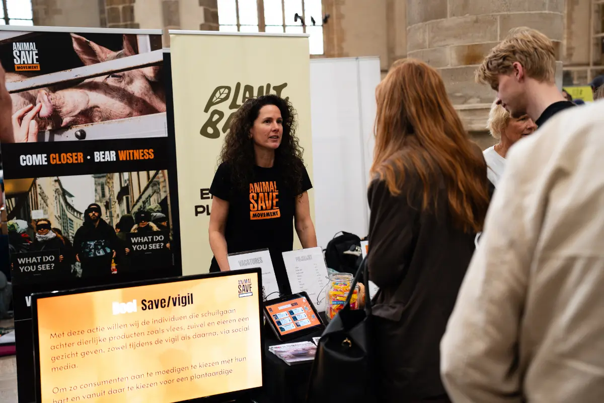 Animal-save-movement-Sharon-duursma Vrouw achter de stand van Animal Save Movement praat met bezoekers.