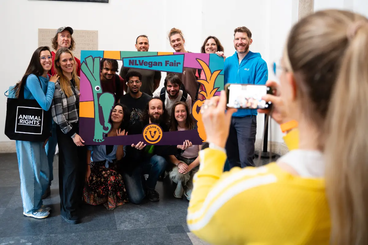 Poseren-op-NLVegan-Fair-Sharon-Duursma Een groep van 13 mensen poseert met het fotoframe van de NLVegan Fair.