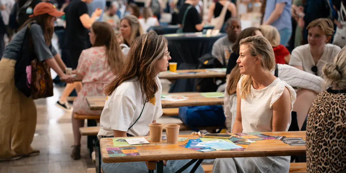 Foto van twee mensen aan een picknicktafel tijdens de NLVegan Fair.