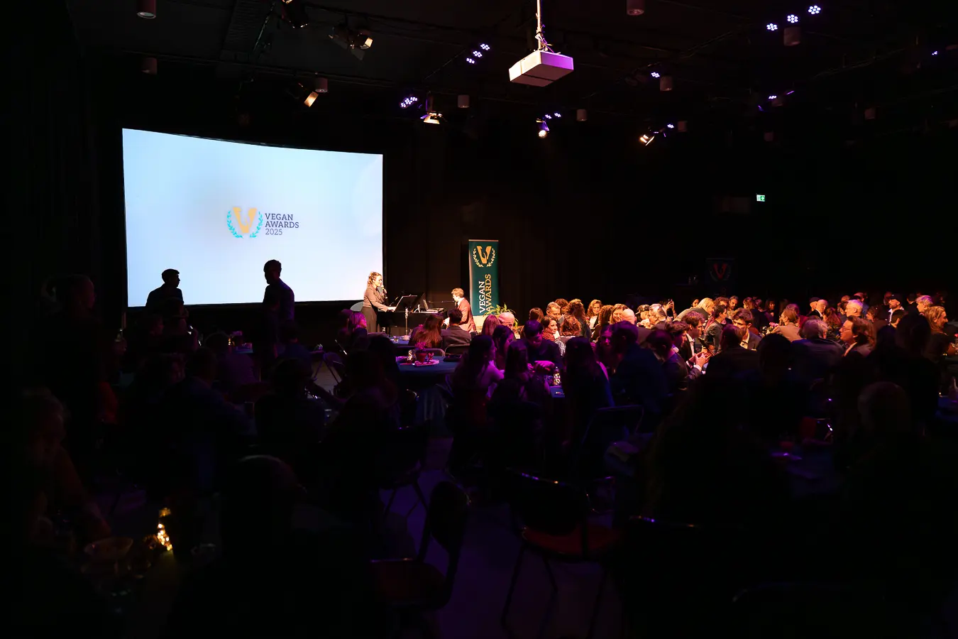 Foto van de hele zaal gevuld met zittend publiek.